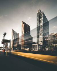 Road by buildings against sky