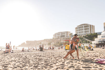 People on beach against clear sky