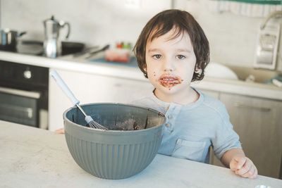 The little boy was smeared with chocolate mixture.