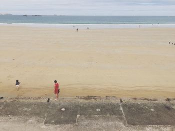 High angle view of mother and daughter at beach