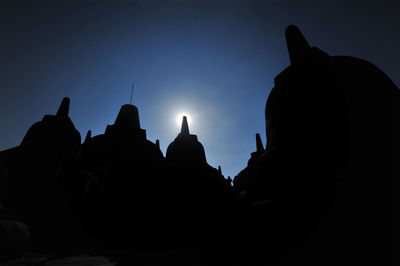 Low angle view of silhouette temple building against sky