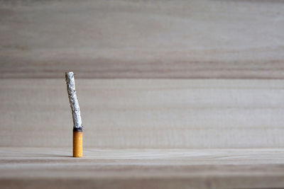 Close-up of burnt cigarette on wooden table