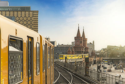 Subway train on railroad tracks by oberbaumbruecke against sky