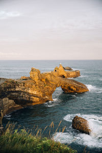 Scenic view of rocks in sea against sky