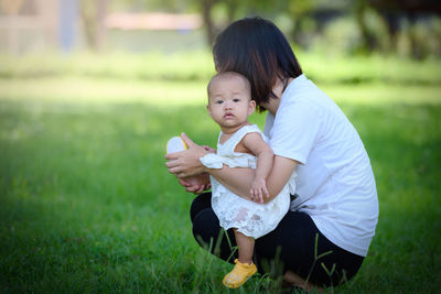 Mother with baby girl on field