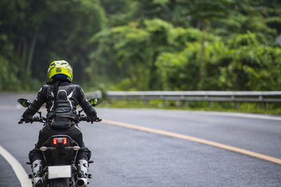 Woamn riding her motorcycle on empty highway in thailand