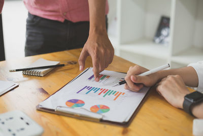 Midsection of woman using laptop on table