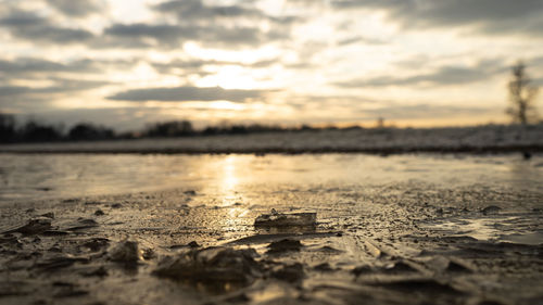 Surface level of sea against sky during sunset