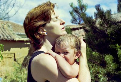 Portrait of mother and daughter against trees