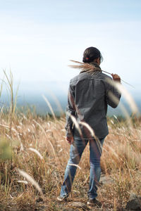 Rear view of woman standing on field