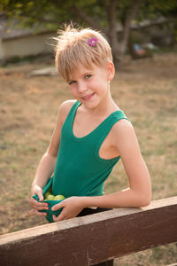 Portrait of boy sitting on wood