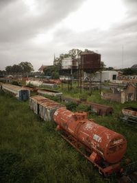 Abandoned train on field against sky