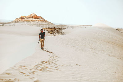 Rear view of man walking in desert