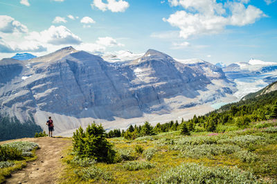 Rear view of man on mountain against sky