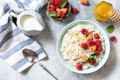 Oatmeal porridge in ceramic bowl decorated with fresh berries raspberries and chia seeds.