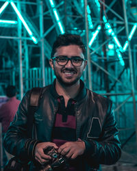 Portrait of smiling young man with digital camera