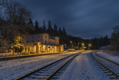 Snow covered railroad tracks against sky during winter