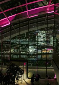 Illuminated building seen through glass window at night