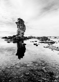 Scenic view of rocks on sea against sky