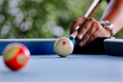 Close-up of hand playing with ball on table