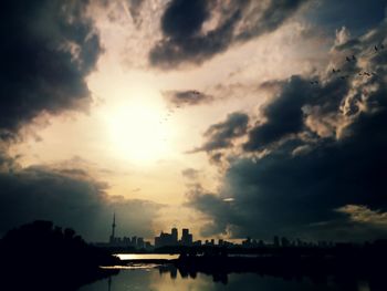 View of river against cloudy sky at sunset