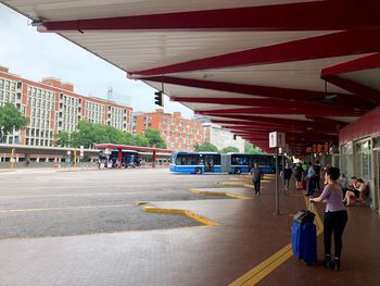 Rear view of people walking on street in city