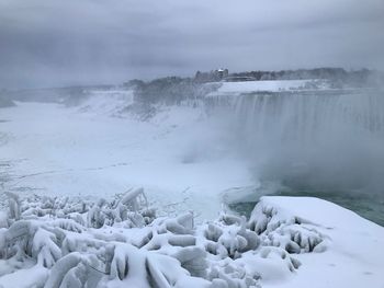 Scenic view of niagara falls against cloudy sky during winter