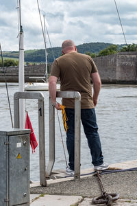 Man standing on boat against sky