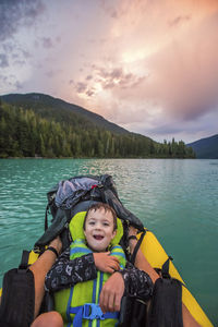 Young boy smiles, laughs during father son paddling trip. on the move