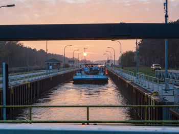 Bridge over canal against sky during sunset