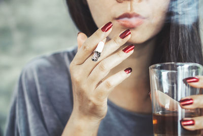 Midsection of woman drinking glass