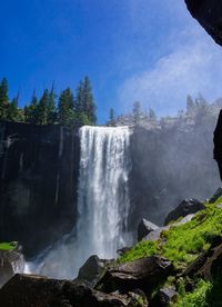 Scenic view of waterfall against sky