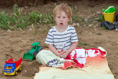 Full length of boy sitting on toy car