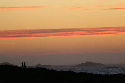 Scenic view of dramatic sky over silhouette landscape