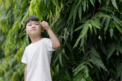 Boy standing against plants