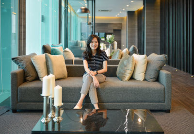 Portrait of woman sitting on sofa at home