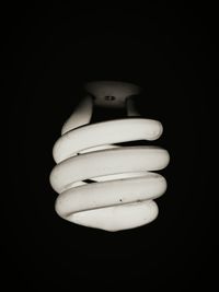 Close-up of illuminated light bulb against black background