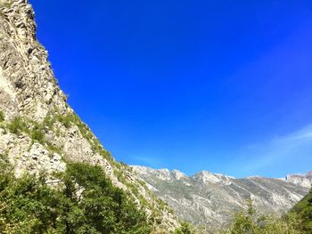 Low angle view of mountain against blue sky