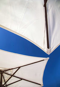 Low angle view of parasol against blue sky