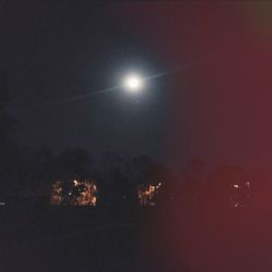 Low angle view of illuminated lights against sky at night