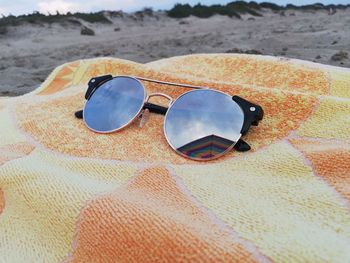 Close-up of sunglasses on sand