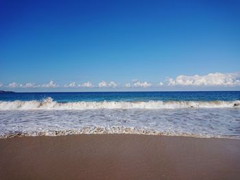 Scenic view of beach against blue sky