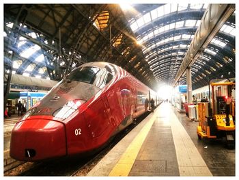 Red train on railroad station platform