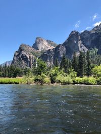 Scenic view of lake and mountains against blue sky