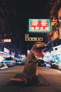 Man on illuminated city street at night