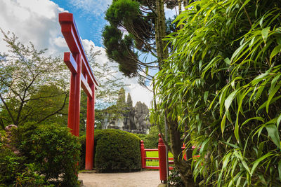 Red built structure by trees against sky