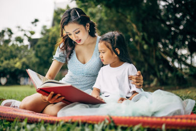 Happy young woman sitting on book