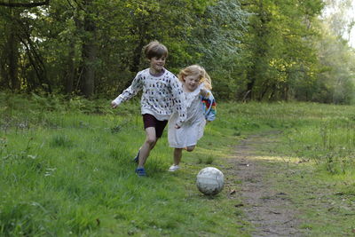 Full length of mother and daughter on soccer field