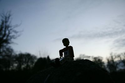 Low angle view of silhouette boy against sky