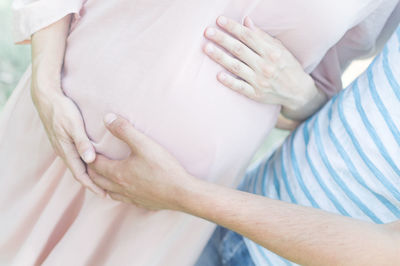 Midsection of woman with arms raised